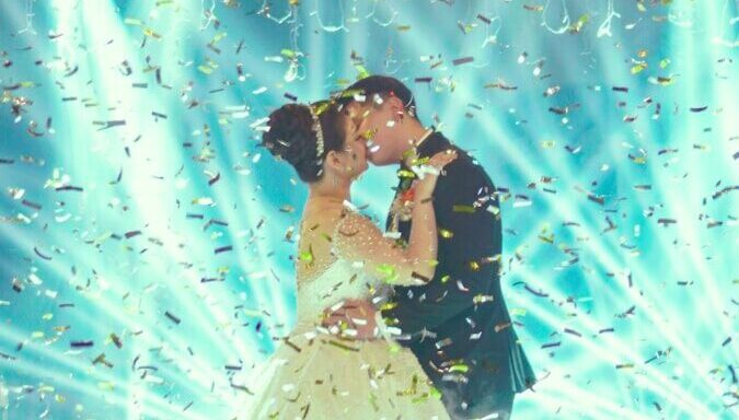 woman in white wedding dress holding blue string lights